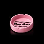 Cendrier en silicone Blazy Susan rose avec logo en relief et quatre encoches - fond noir studio, boutique Nature Lab